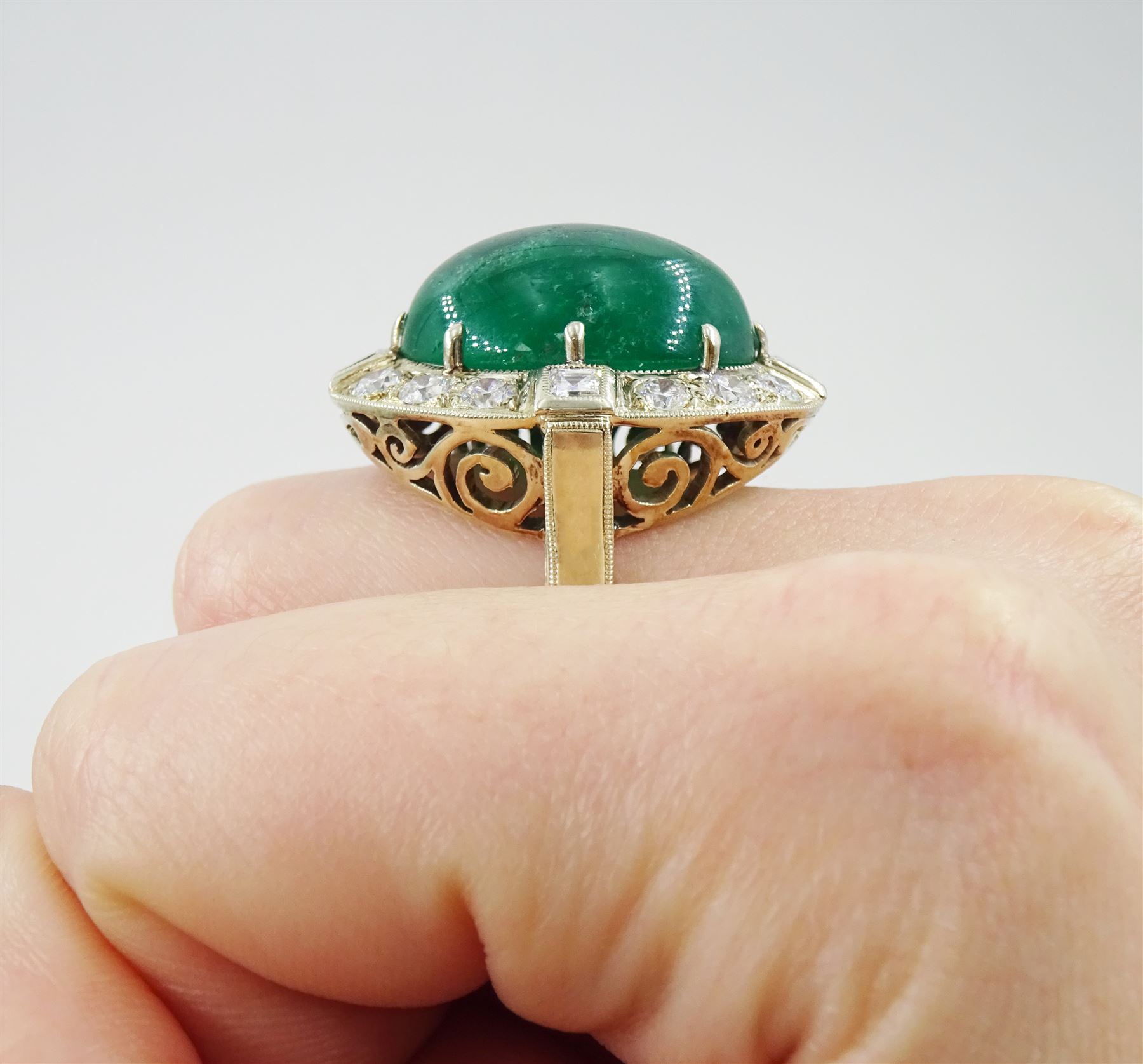 Gold emerald and diamond ring, the central oval cabochon emerald, with sixteen round and rectangular cut diamond halo surround by Judith Crowe, hallmarked 9ct, emerald 20.00 carat, total diamond weight 2.00 carat, with World Gemological Institute report