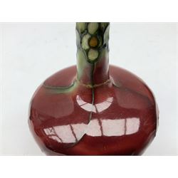 Three Minton Secessionist vases, with tube-lined stylised flower decoration, two upon a red ground and third upon a purple ground, all with printed mark to base 'Minton Ltd, No. 33', H13cm
