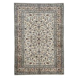 Persian Kashan ivory ground rug, decorated with curled leafy branches and palmettes, the border with scrolling design decorated with further palmettes, within floral pattern guard stripes