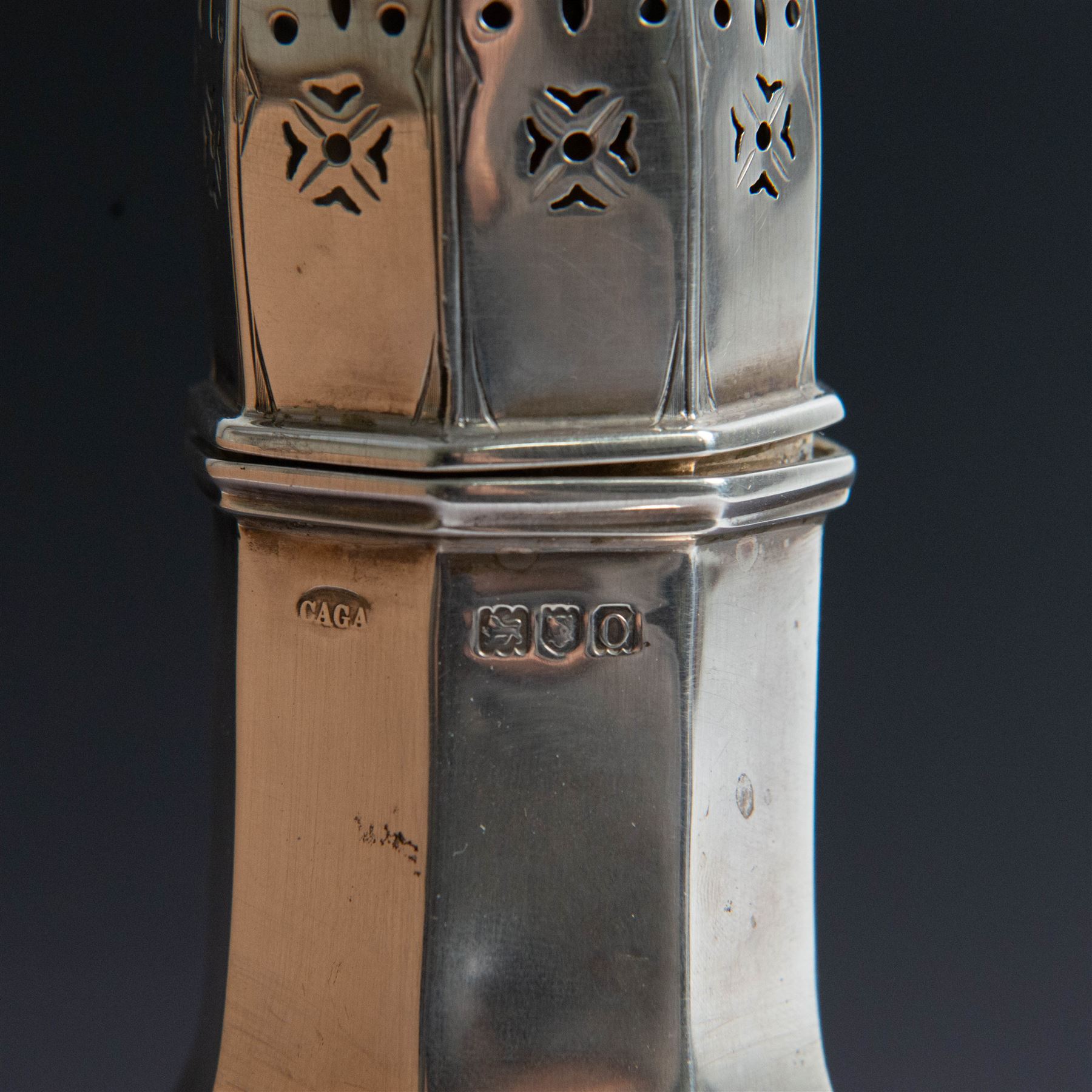 Edwardian silver sugar caster, of octagonal urn form, upon an octagonal foot, the removable pierced cover with urn finial, hallmarked Charles & George Asprey, London 1909, H21cm 