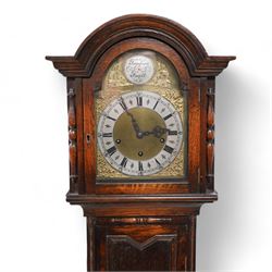 Oak cased 8-day grandmother clock c 1930 - with a broken arched pediment and break arch hood door flanked by turned pilasters, carved full length trunk door on a short plinth raised on bun feet, brass dial with cast spandrels, matted dial centre and silvered chapter with Roman numerals, three train spring driven movement chiming the quarters and hours on 8 gong rods.  With pendulum.
