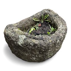 Collection of cast stone garden objects including mill stone, trough, planter, and faces