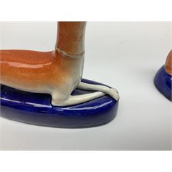 Pair of Staffordshire recumbent greyhound pen holders 
