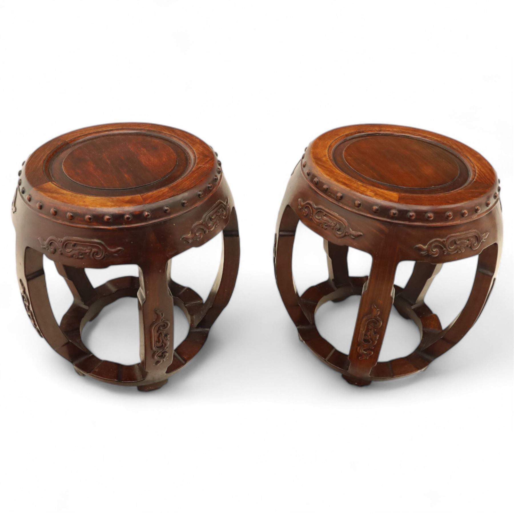Pair of early 20th century Oriental hardwood barrel seats, of drum form with shaped apron and pierced panels, carved with stylised scrollwork and studded detail to the top