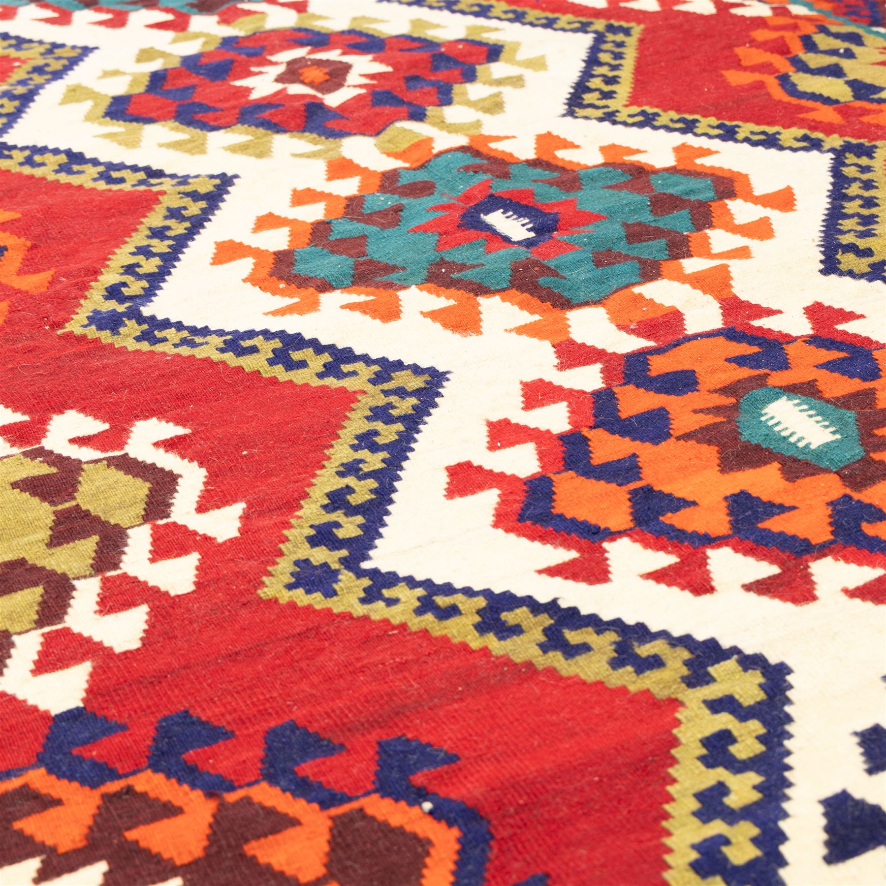 South west Persian Qashqai flatweave kilim, central field with a linked column of hooked diamond medallions in polychrome tones with an ivory lattice on a magenta ground framed by multiple geometric borders 