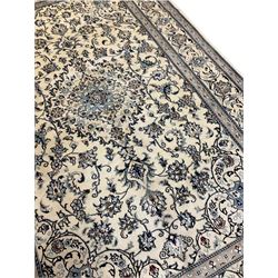 Central Persian Nain rug, wool with silk inlay, ivory ground decorated with scrolling and interlaced branch with stylised plant motifs, central floral medallion, triple band border with repeating design