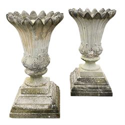 Large pair composite stone urns, fluted bud shaped urns with an anthemion moulded bulbous base, circular column on square base, on stepped and moulded plinth

Location: Duggleby Storage, Scarborough Business Park YO11 3TX