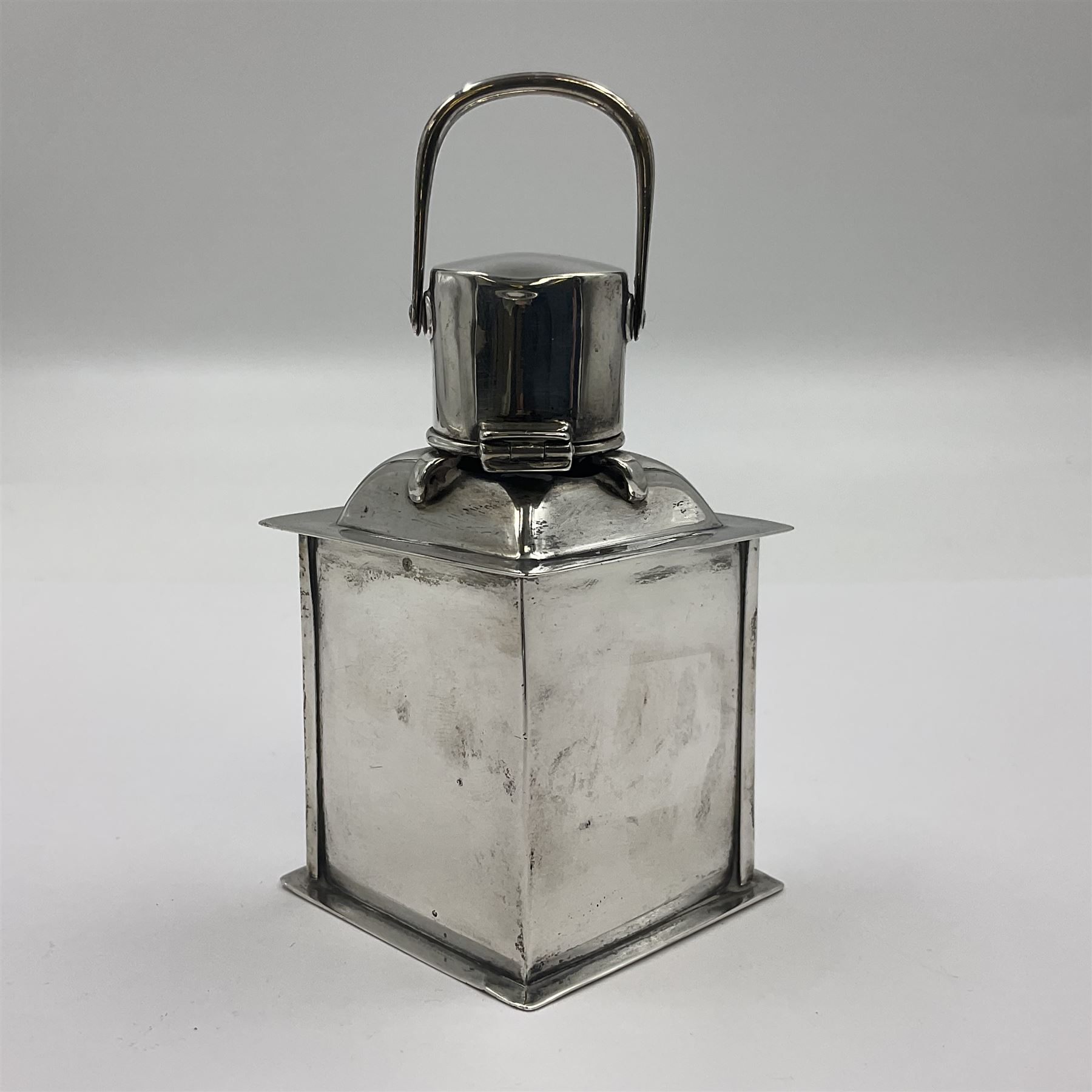 Early 20th century silver novelty inkwell, modelled as a ship's port lantern, with swing handle, convex red glass panel and hinged cover opening to reveal a glass liner, hallmarked Samuel Jacob, London 1911, height not including handle H8.5cm