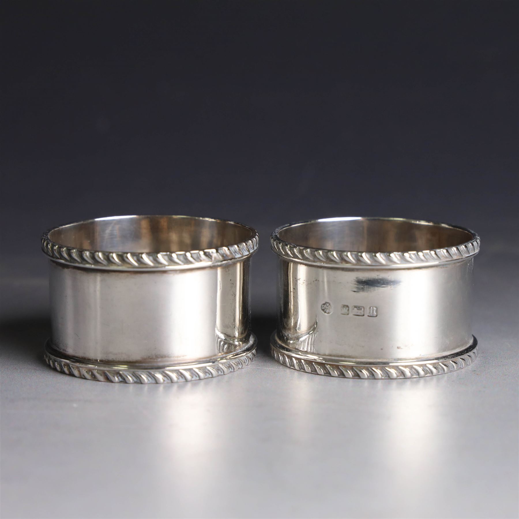 Pair of early 20th century silver napkin rings, plain circular form with oblique gadrooned rim, no engravings, hallmarked William Hutton & Sons Ltd, Sheffield 1912