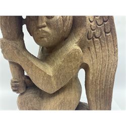 John Bunting FRBS, FRCA (1927-2002): Carved hardwood candle holder, in the form of an kneeling angel, holding aloft a copper dish, H42cm