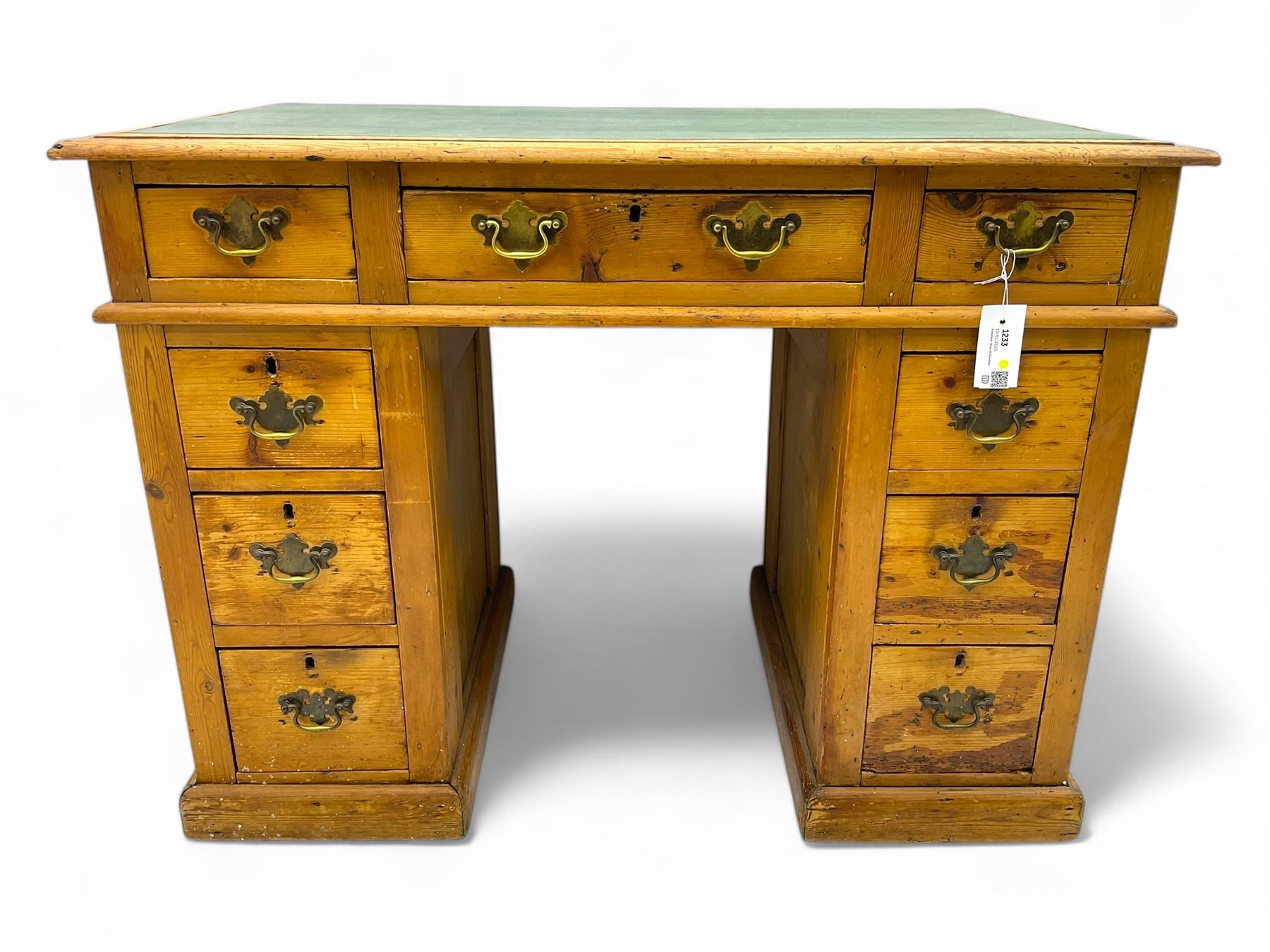 Rustic pine twin pedestal desk, rectangular green leather inset top above a central frieze drawer flanked by two short drawers, each pedestal featuring three graduated drawers, raised on a plinth base