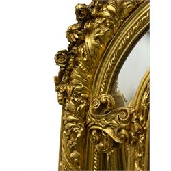 Large Italian Baroque design gilt wall mirror, the shell pediment over circular panel depicting classical female flute player with dancing putto within a tree landscape, the stepped arched upper frame surmounted by musical instrument playing putto and trailing flower heads, central bevelled mirror plate surrounded by plain segmented mirror plates, acanthus leaf moulded outer frame and foliate moulded inner slip