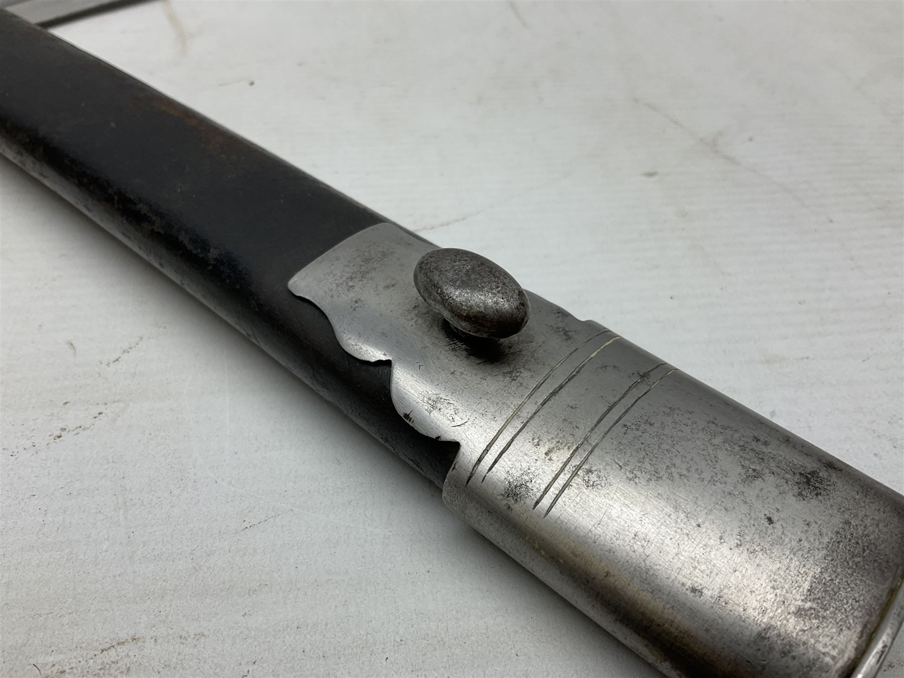 Mid-19th century Custom’s officer/Constabulary sidearm, with plain 60.5cm slightly curving fullered blade double edged at tip,  steel knucklebow and downswept quillon, stepped pommel and ribbed fishskin grip; in leather covered scabbard with steel locket, frog stud and chape L76cm overall