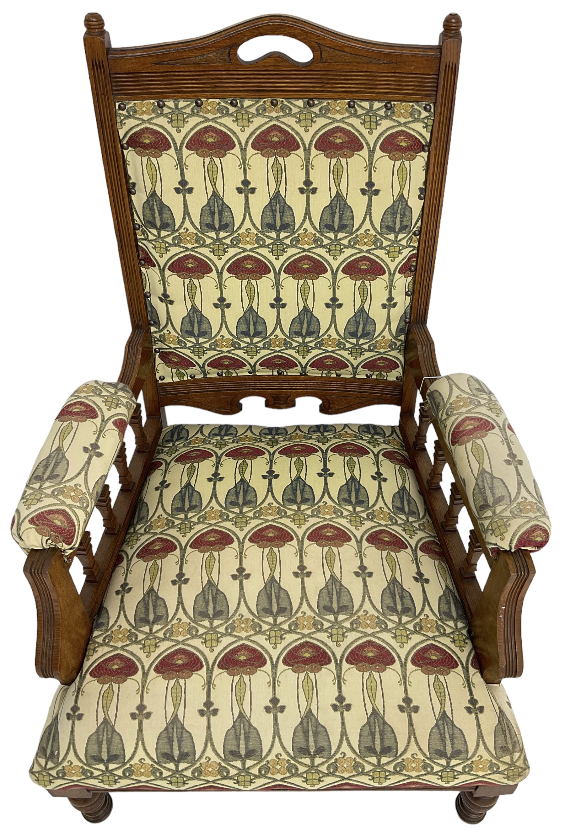 Early 20th century armchair, back and sprung seat upholstered in Art Nouveau patterned fabric, raised on ring turned supports, the frame with all-over reeded decoration