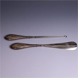 Early 20th Century silver mounted dressing table set, comprising hand mirror, shoe horn and a button hook, each with engraved floral decoration, together with a silver mounted hairbrush and clothes brush, all hallmarked