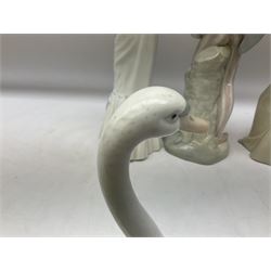 Lladro 'Walk With the Dog' figure no. 4893, together with Lladro swan figure, Porceval figure of a gentleman with a bird perched upon his hand and a further of a lady with flowers beside a basket, all with marks beneath, tallest H40cm