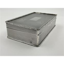 1920's silver table cigarette box, of rectangular form with engine turned decoration to the exterior, the hinged cover with central vacant rectangular panel and raised foliate rim, opening to reveal a gilt interior with later plush lining, hallmarked Charles Henry Dumenil, London 1923, H3.5cm L14.5cm D8.5cm