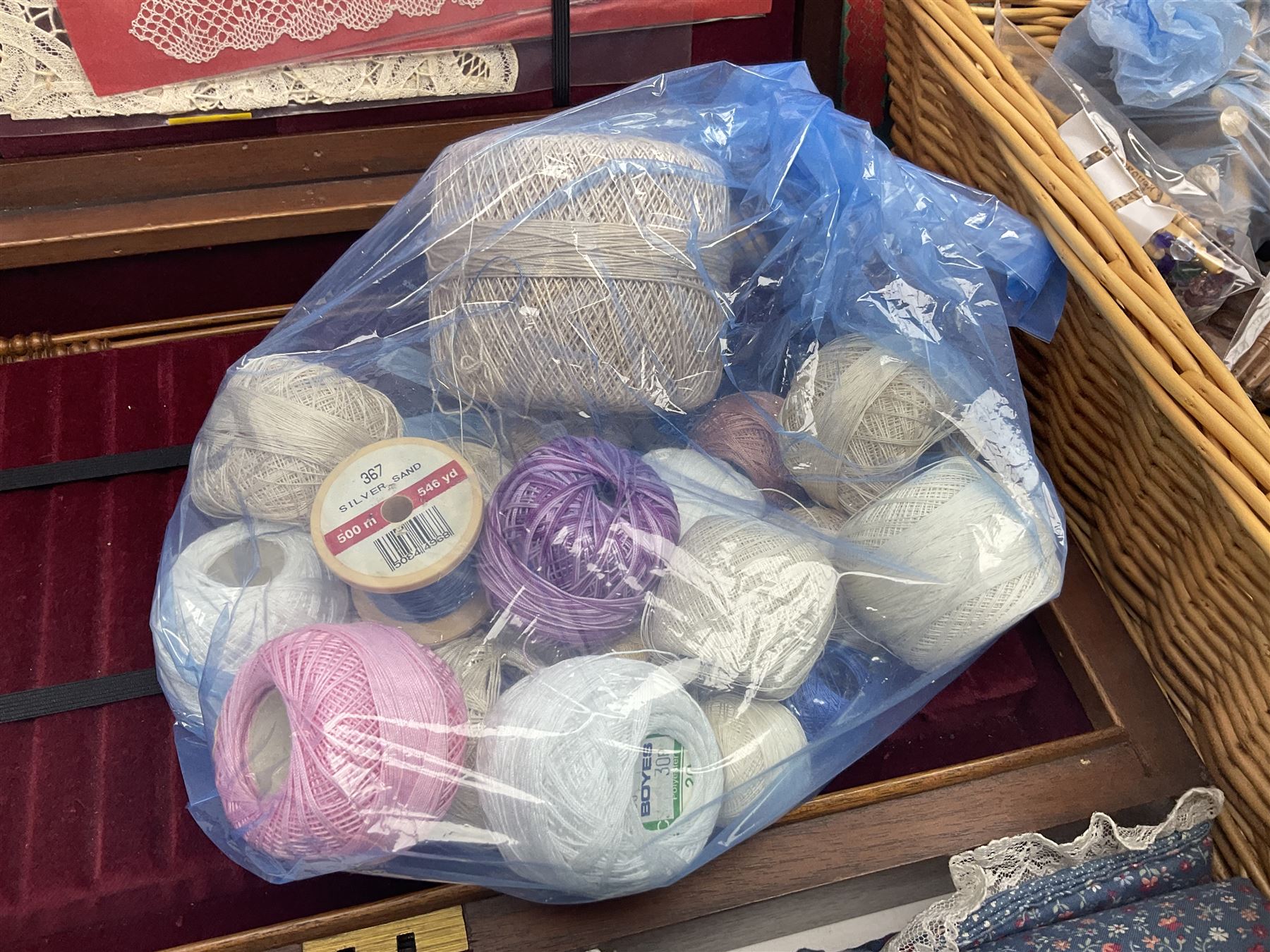 Collection of lace making wooden bobbins, together with lace making books and a handmade storage box