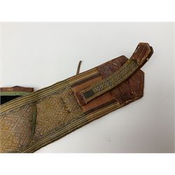 Late 19th century Yemeni Tuza jambiya as worn by religious elite, the 20.5cm curving blade with raised medial ridge, the horn hilt with pique style studwork, in a leather wrapped wooden scabbard with pierced metal mount and leather belt applied with embroidered 'gold' and 'silver' thread work panel; dagger L36cm overall, belt L84cm