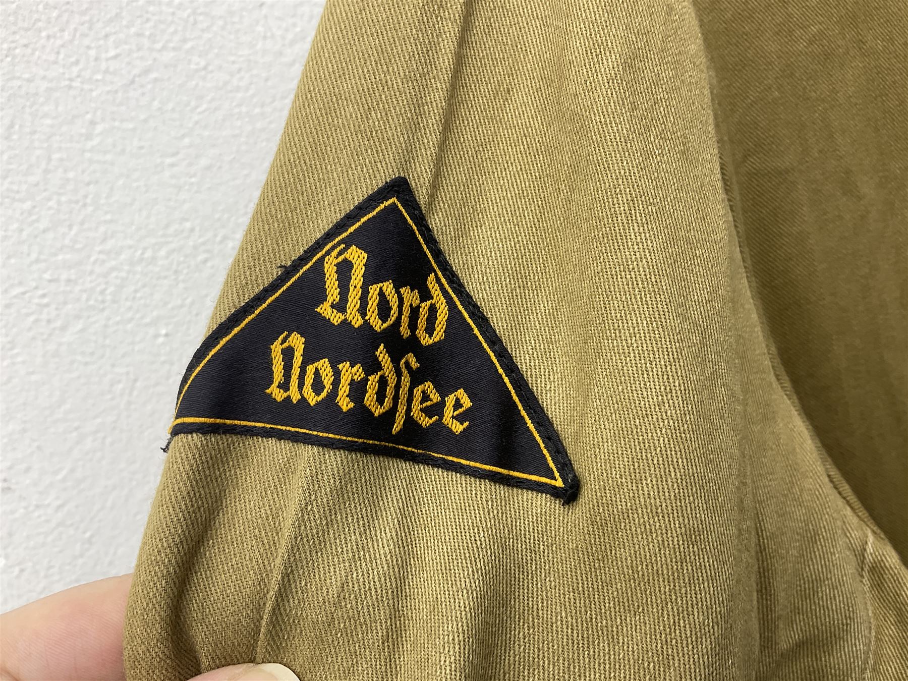1930s Hitler Youth brown shirt, long length with two pockets, bears triangular badge 'Nord Nordsee'