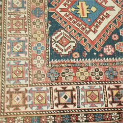 Vintage Caucasian Shirvan hand-knotted rug, indigo field with an arrangement of geometric diamond medallions and stylized tribal motifs within multiple patterned borders, with fringe ends 