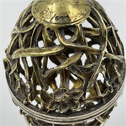 Modern silver limited edition Easter egg, no. 70/500, the gilt openwork body decorated with daffodils and detachable cover with pierced circular panel set with a single faceted blue stone, opening to reveal a gilt interior, upon silver stand with three scrolling pad feet, each hallmarked St James House Company, London 1980, height including stand 8cm