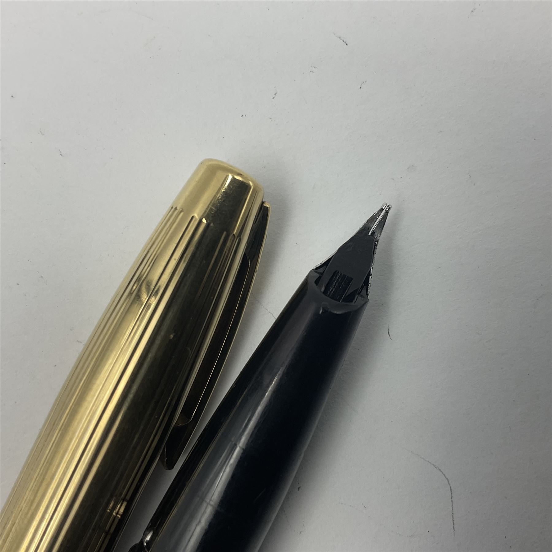 Sheaffer Crest fountain pen, the black barrel with gold plated cap and 18K nib, together with a matching ballpoint pen and further fountain pen, longest L14cm (3)