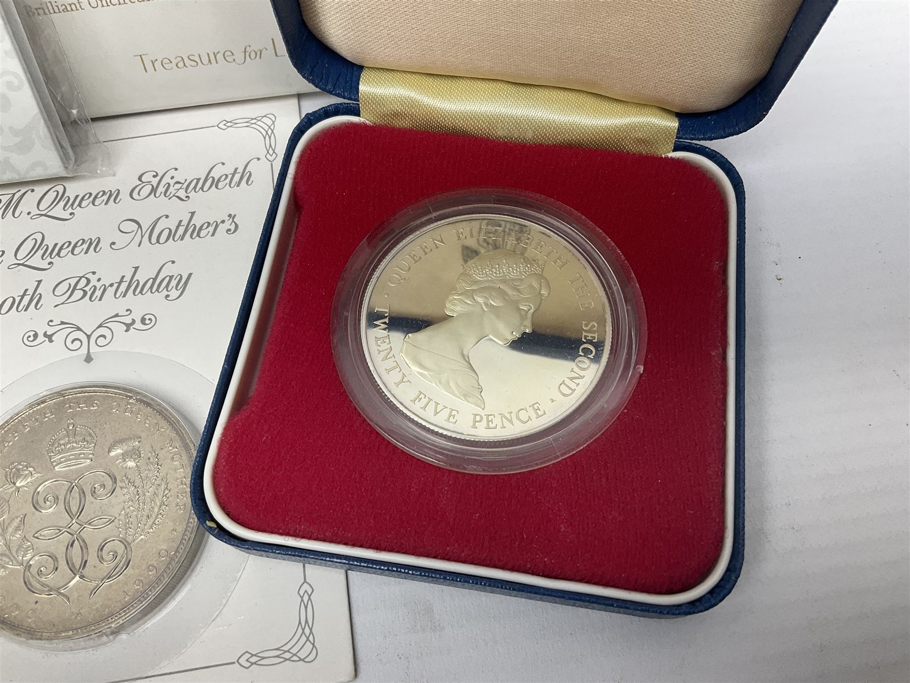 Queen Elizabeth II 1977 silver crown and 1980 silver crown, both cased with certificates, Bailiwick of Guernsey 1978 silver crown cased without certificate, three United Kingdom brilliant uncirculated five pound coins in card folders and twelve other five pound coins