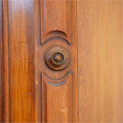 Victorian late 19th-century mahogany wardrobe, moulded cornice with rounded corners above arched mirror door, flanked by arched panels and side with carved corbels, on plinth base  