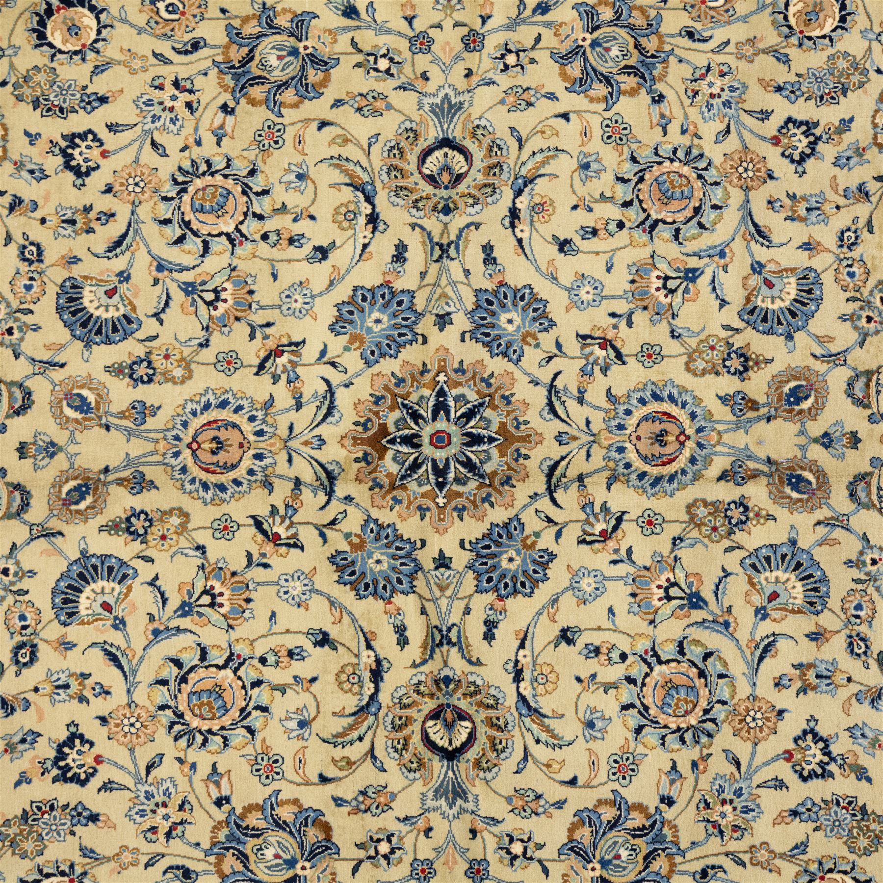 Persian Kashan carpet, beige ground, field with an all-over design of scrolling palmettes and floral sprays in blue and terracotta within a ivory ground and pale blue floral border
