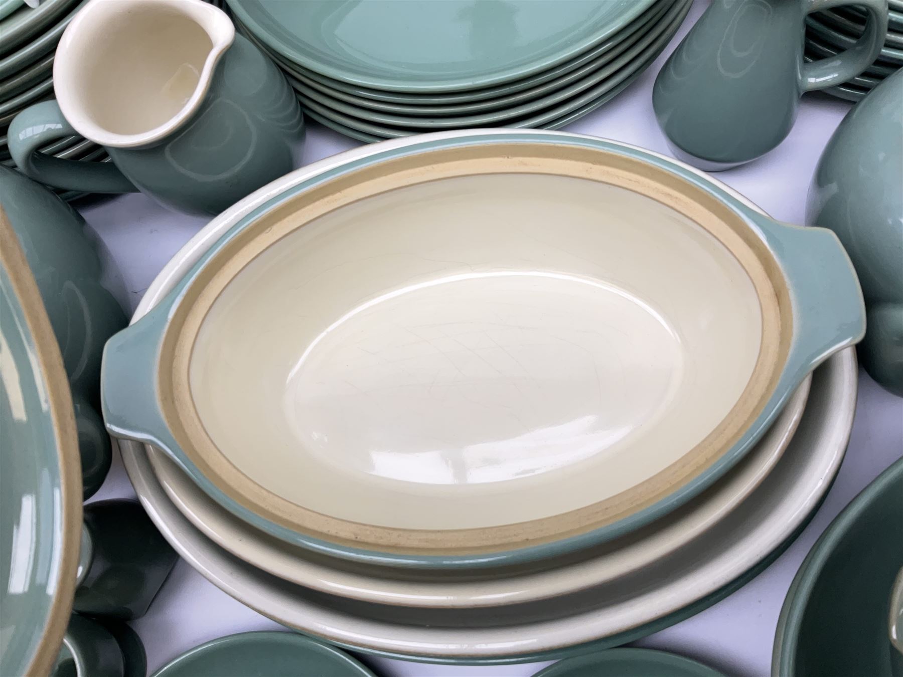 Denby Manor Green pattern part tea and dinner service, to include seven dinner plates, thirteen side plates, ten dessert plates, two oval dishes of various sizes, four cups and saucers, seven bowls with covers, two teapots etc (74)  