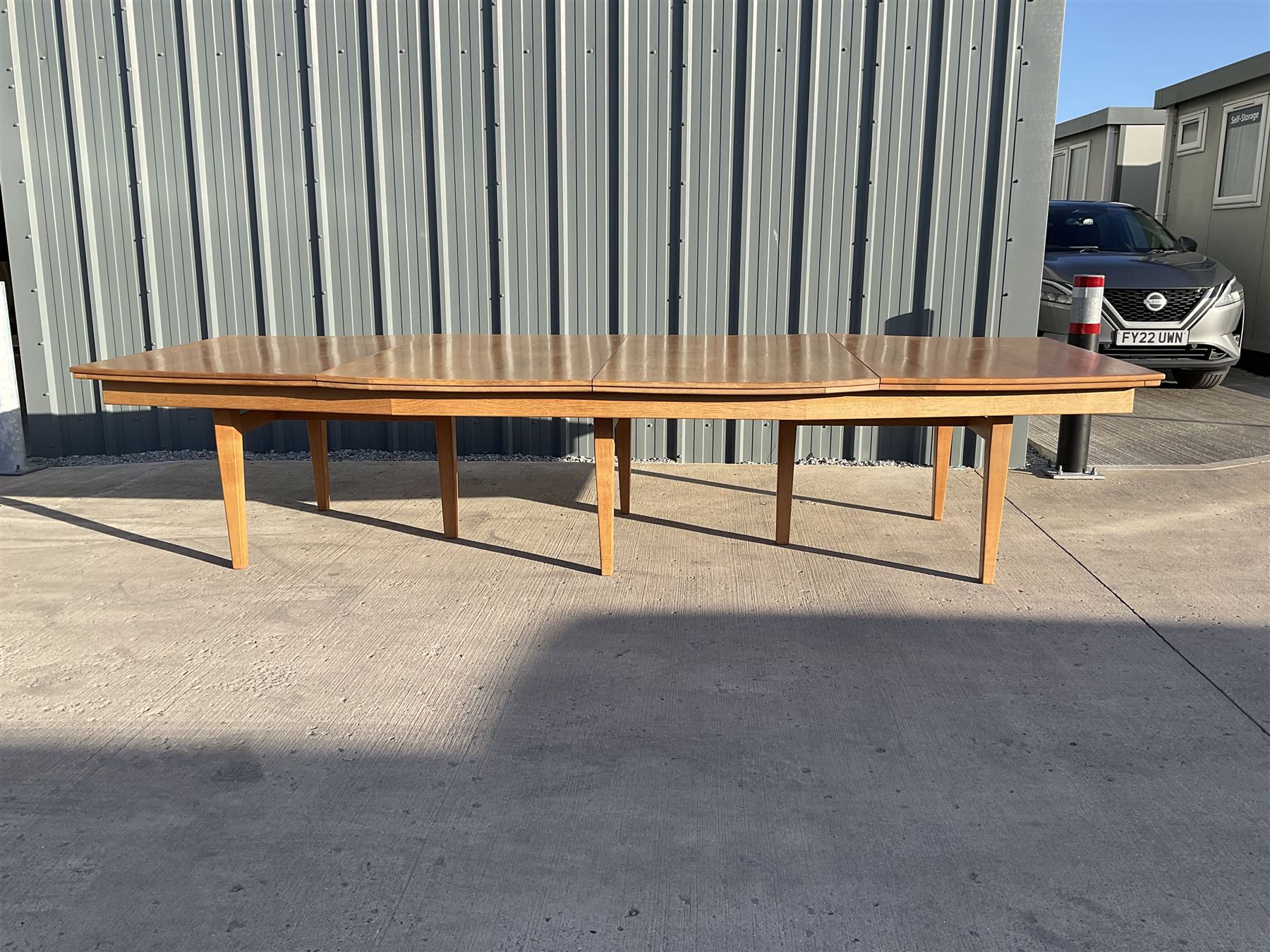 Light oak bespoke boardroom table, concave form, four sectional top on square discreet legs (12' x 5'), with twelve armchairs including 'Chairmans' chair