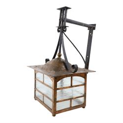 20th century, Arts and Crafts style copper porch lantern, of rectangular form, with cast iron scrolling wall fittings