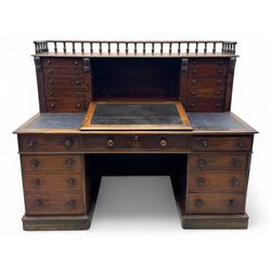Large Victorian mahogany Registry/Dickens’ desk, spindle gallery top, one side with five small drawers and the other with blind cupboard drawer, revealing pigeon holes with scroll carved locking side bars on either side, above a hinged and leathered writing slope with three drawers and pigeon holes underneath, above a central locking drawer with key, the pedestals each with four drawers and  turned knob handles, separates into four parts for transport