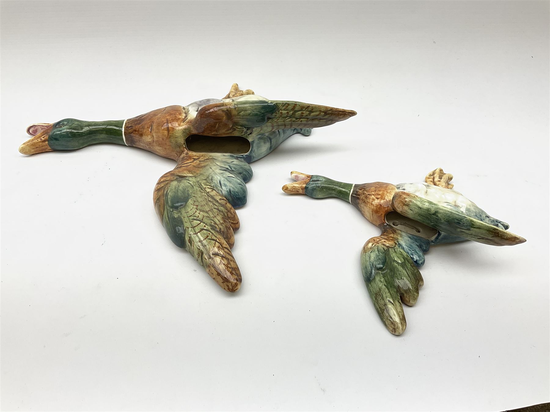 Two Royal Dux wall mounted ducks in flight, both with printed marks verso detailed Made In Czechoslovakia, and impressed marks, largest example L32.5cm, smallest example L21.5cm. 