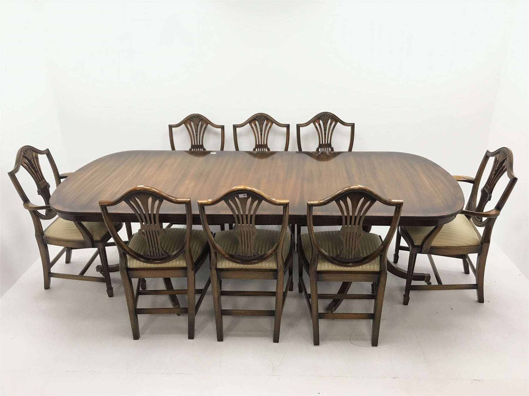 Rackstraw - Georgian style mahogany twin pedestal dining table with single leaf, turned columns on six shaped supports (W180cm and W240cm, H79cm, D104cm) and set eight (6+2) Hepplewhite style dining chairs, shaped cresting, upholstered serpentine seat, square tapering supports on spade feet (W58cm)