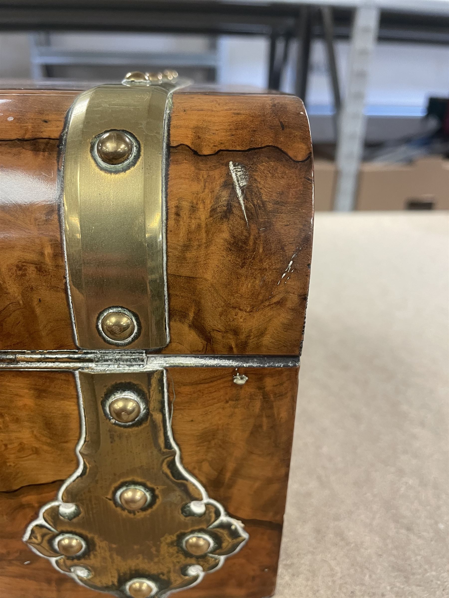 19th century walnut and brass bound games compendium box, painted to enhance the grain, of rectangular form, the hinged opening cover with rounded sides, central brass cartouche with engraved lion crest, and brass riveted straps, opening to reveal a red leather and blue silk lined compartmented interior, with fold-down games board, and lift-out tray containing playing cards, ebony turned dice towers, white and red stained bone draughts, and chess pieces, ivory dice, and ivory and ebony whist markers, and brass bezique board, cribbage board and markers, H15cm W32cm D24cm
This lot has been registered for sale under Section 10 of the APHA Ivory Act