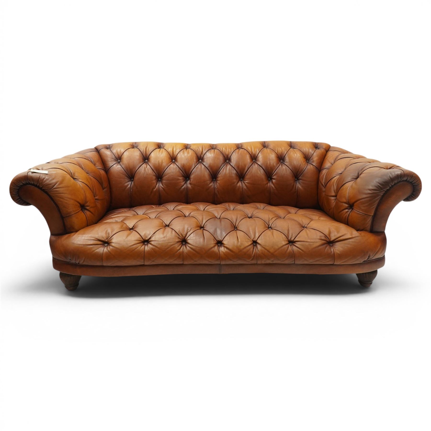 Tetrad - 'Oskar' grande three-seat sofa, Chesterfield shape with rolled arms over serpentine back and front, upholstered in fully buttoned tan leather, raised on reed-moulded feet of globular form
