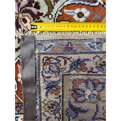 Central Persian Najafabad hand-knotted carpet, the ivory field with a central floral medallion radiating palmettes and arabesques in tones of blue, lilac and tan, enclosed by a wide navy border of scrolling vine and rosette motifs, with red spandrels and multiple guard stripes