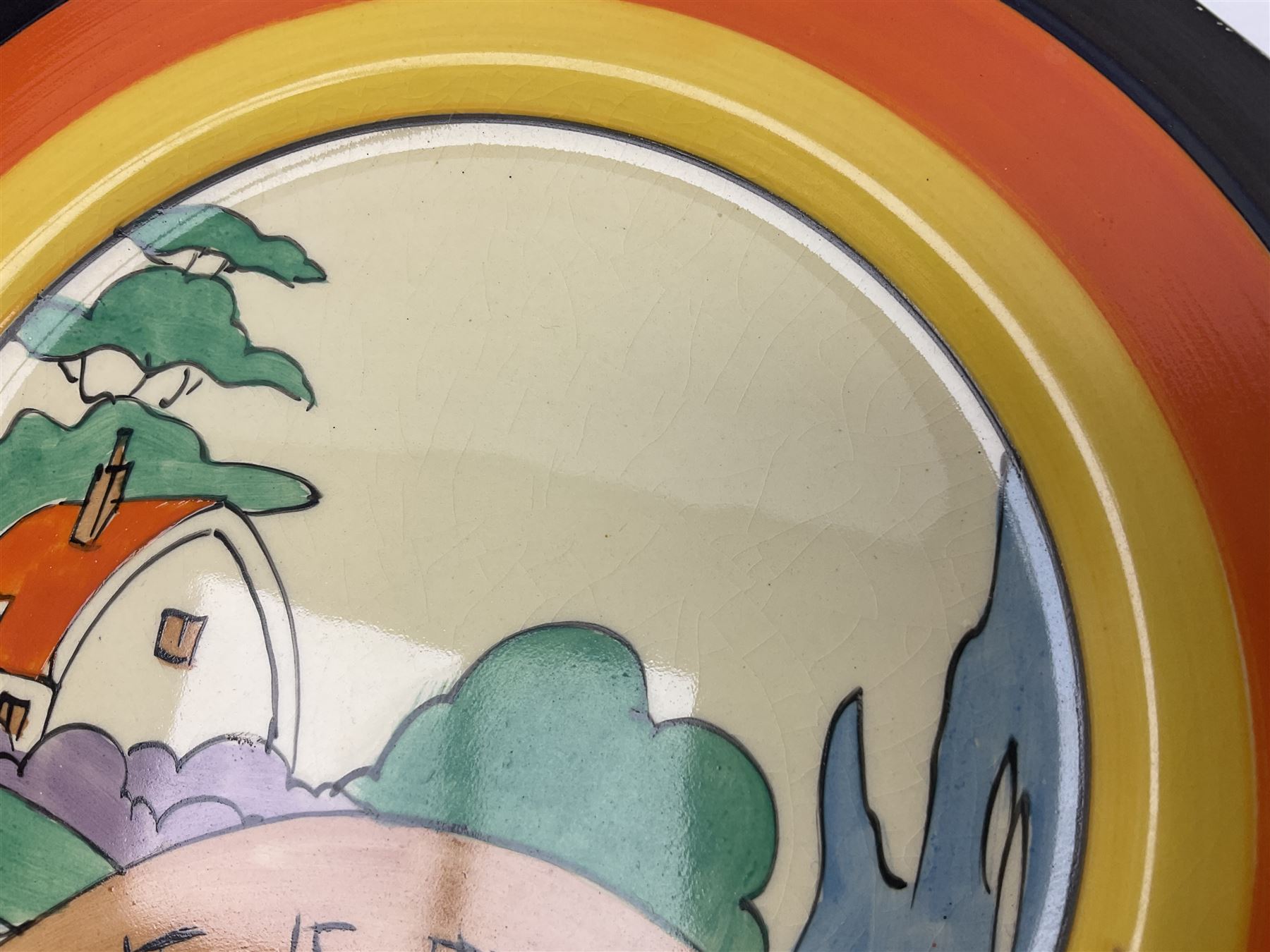 Clarice Cliff Bizarre for Newport Pottery Orange Roof Cottage pattern plate, circa 1932, hand painted with a stylised cottage and bridge landscape with yellow, orange and black banding, black printed mark beneath, D22cm 