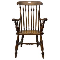 Early 19th century elm farmhouse armchair, the shaped eared cresting rail over tall spindle back, dished seat on turned supports united by H stretchers