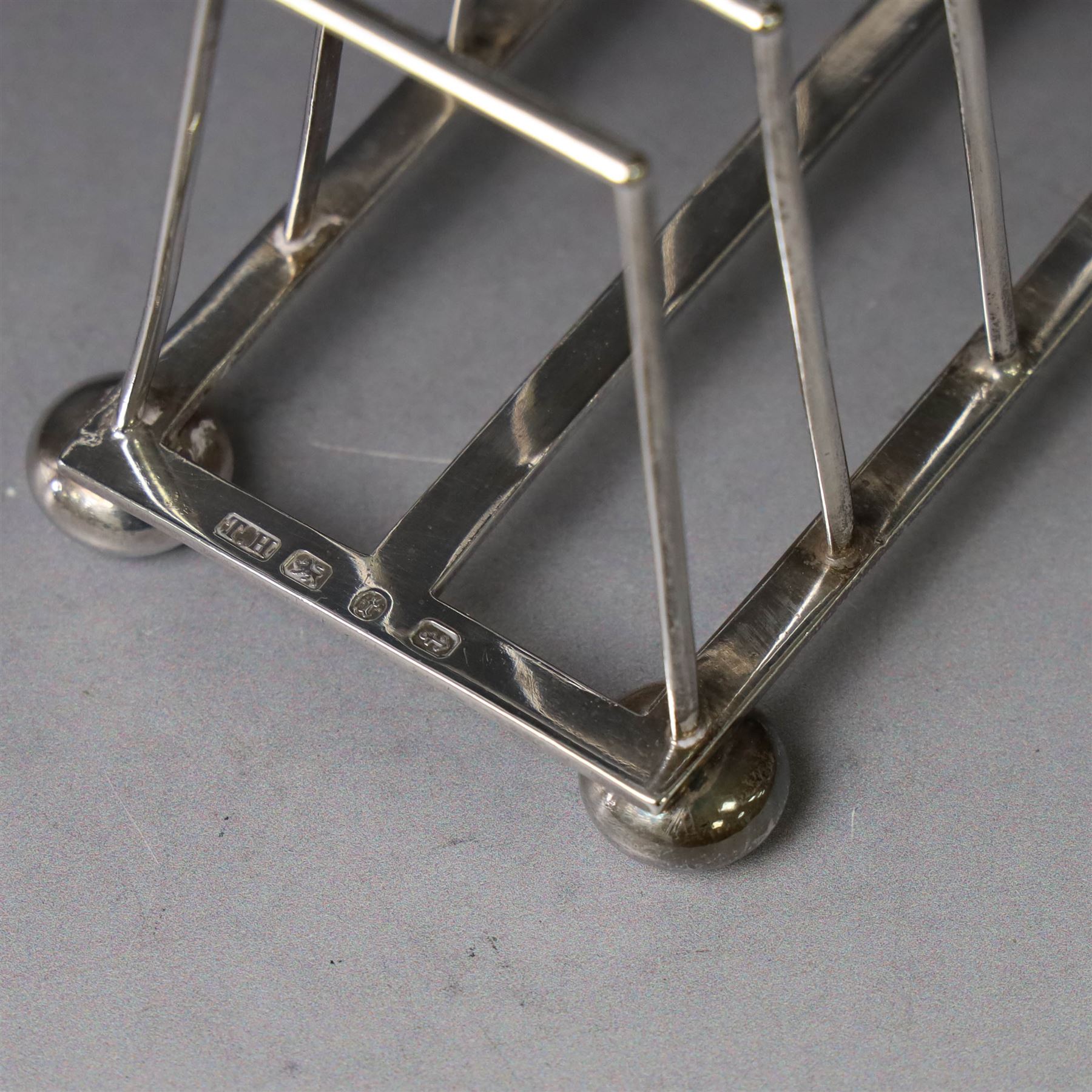 Victorian silver toast rack, with five angular bars and loop handle, upon four squat bun feet, hallmarked Thomas Hayes, Birmingham 1893, height including handle H10cm