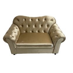 Chesterfield shaped snuggler sofa, upholstered in buttoned champagne fabric, with scatter cushions
