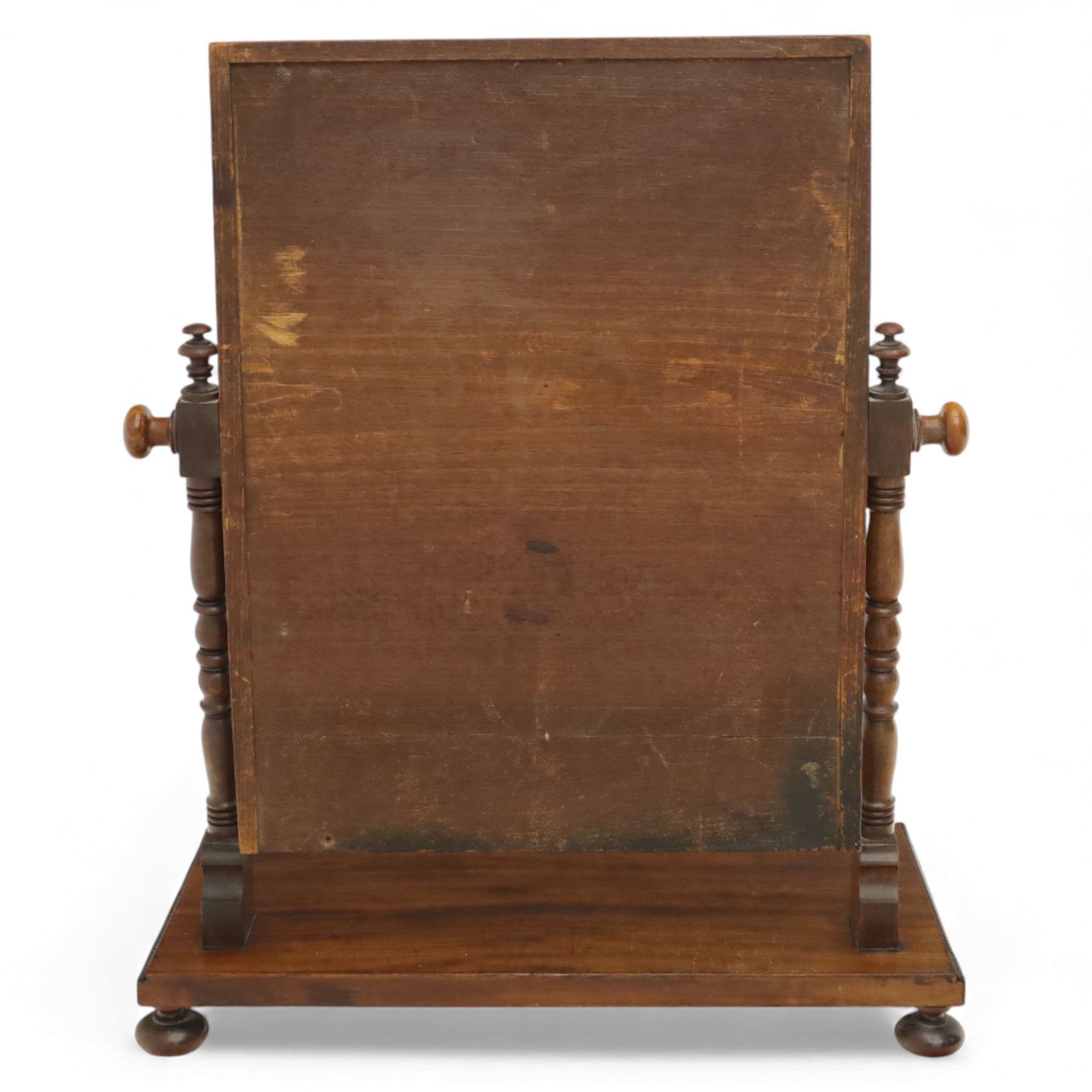 Two early 20th century mahogany swing dressing mirrors, comprising one with arched rectangular plate in a moulded frame on shaped supports, flanked by two inlaid trinket drawers (H 69cm, W 88cm, D 20cm), together with another rectangular plate mirror on turned supports upon bun feet (H 58cm, W 48cm, D 23cm)