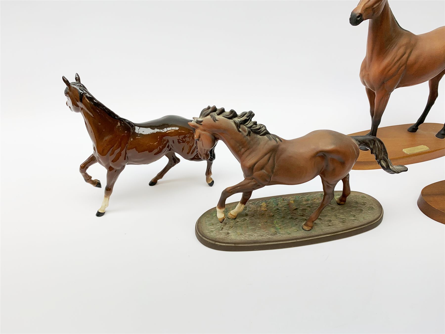 Four Royal Doulton horse figurines, comprising Red Rum, Arkle, and the Winner DA154, and another modelled as a prancing bay horse, largest H32cm. (4). 