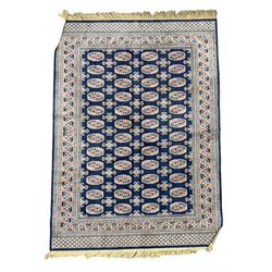 Small Persian blue and ivory ground rug (182cm x 105cm); Persian design rug decorated with Gul motifs (187cm x 134cm); peach ground rug (226cm x 167cm); and a smaller peach ground rug (178cm x 120cm)