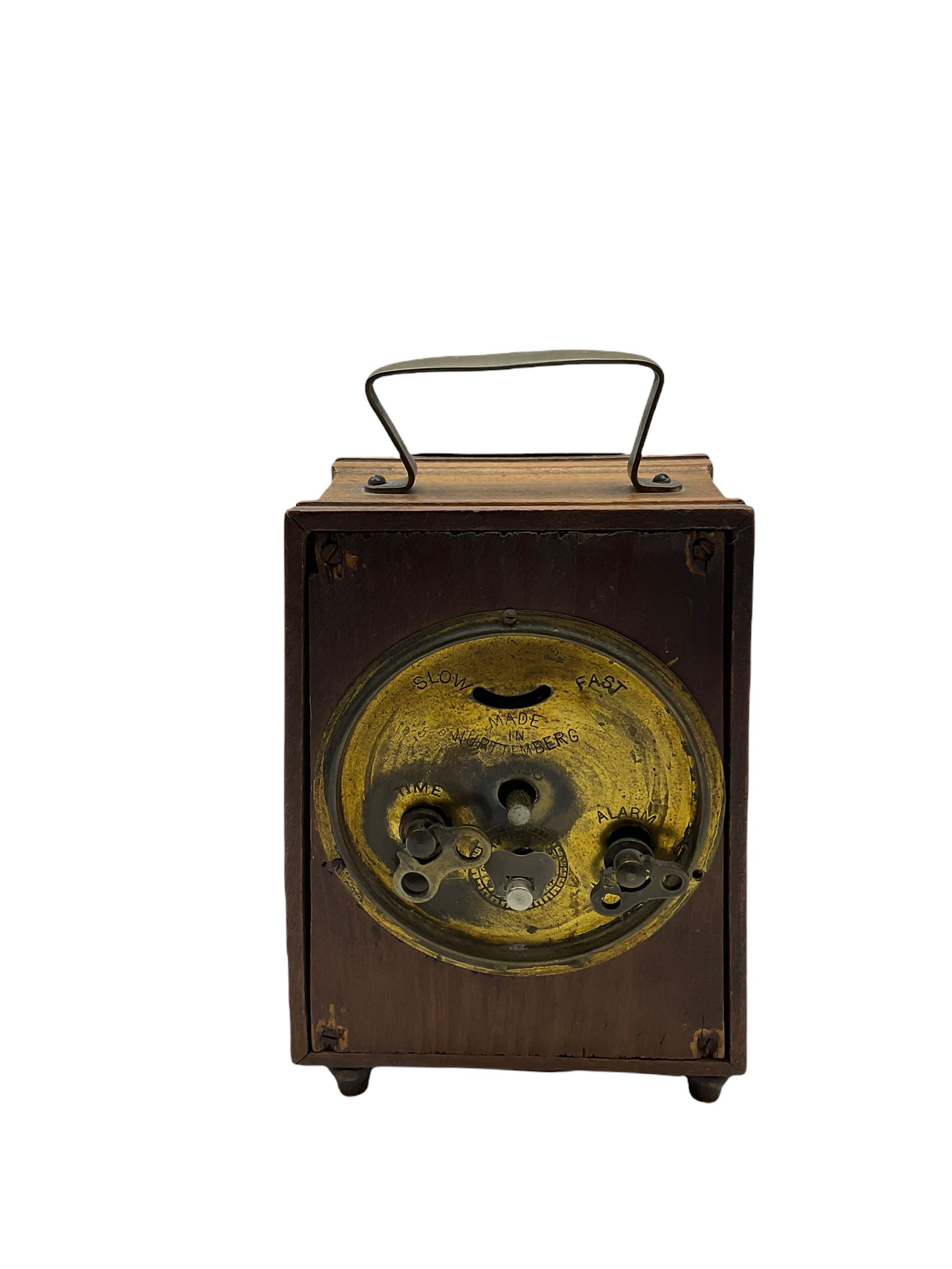 An American “Jerome” late 19th century  30-hour spring driven steeple clock with alarm, in a mahogany case with a decorative glass tablet depicting a rose painted white dial with roman numerals and minute track, steel moon hands and a brass alarm setting disc to the centre. With pendulum and key.
H40 W20 D10
With a small portable 19th century German “Wutternberg” alarm clock, the piece dial with a gilt centre and Ivorine chapter ring, Arabic hours and minute band, wooden case with brass fittings and carrying handle on four feet, wound and set from the rear with integral keys, alarm sounding on a bell. 
H20 W12 D7
