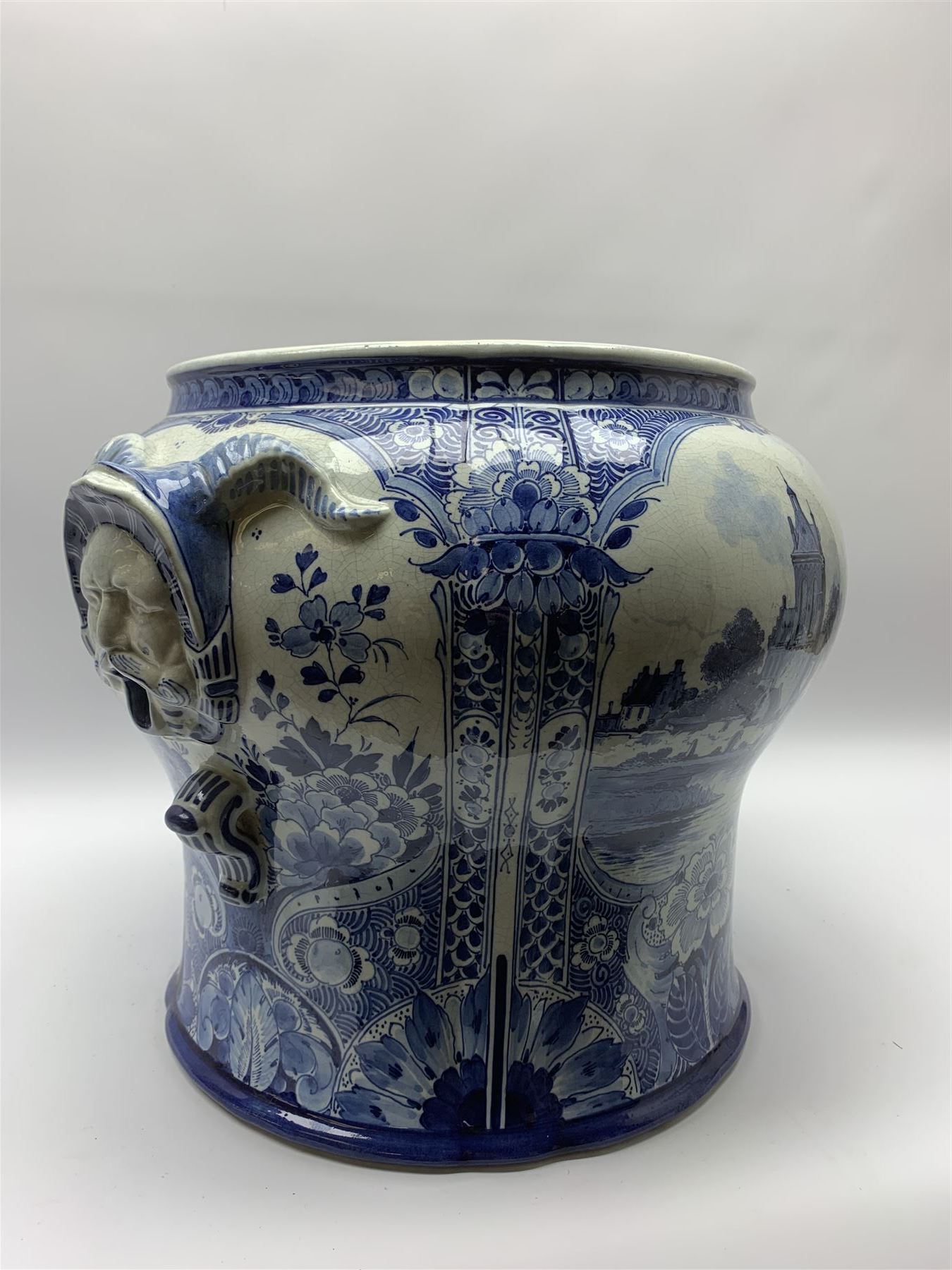 Large 20th century Delft blue and white jardinière, of baluster form with twin zoomorphic mask lug handles, decorated with hand painted panels of waterside scenes, within foliate surround, impressed and painted marks beneath for De Porceleyne Fles workshop, Delft, H35cm, rim D32