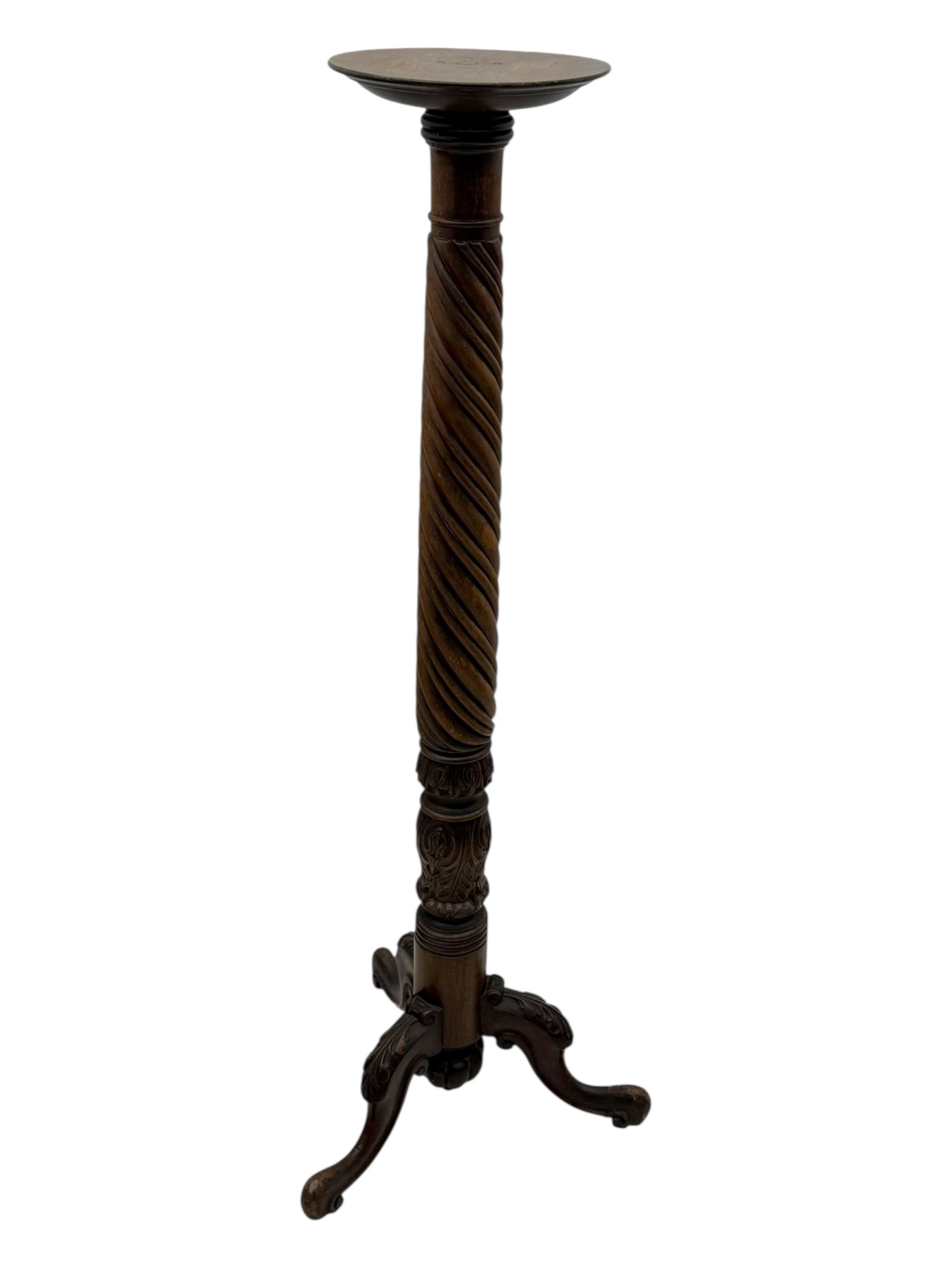 Late 19th century mahogany torchère stand, with circular top above a twisted and foliate carved collumn, on a scroll carved tripod base, on cabriole legs