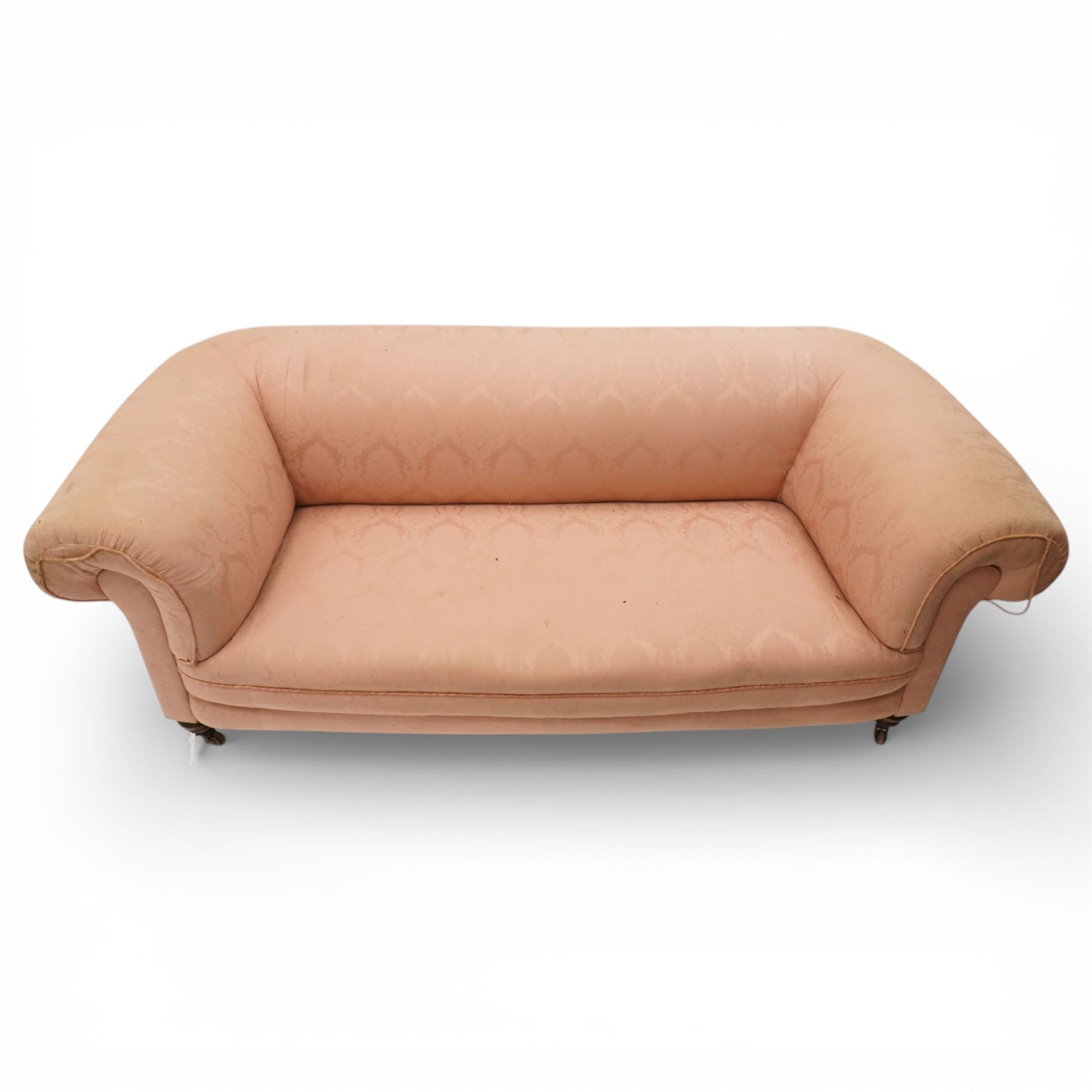 Victorian two seat sofa, upholstered in pink fabric, bowed form with scroll back and arms, raised on turned legs with castors